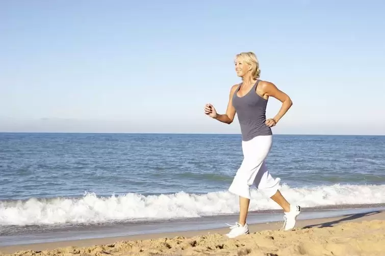 Una donna invecchiata che fa jogging per perdere peso e una buona funzione cardiaca